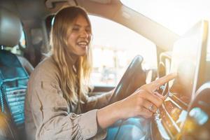 Woman selects the destination with car gps navigator photo
