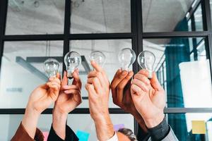 Teamwork and brainstorming concept with businessmen that share an idea with a lamp photo