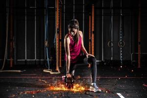 Athletic girl works out at the gym with a fiery kettlebell photo