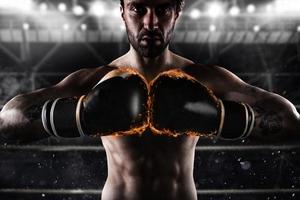 Confident boxer with fiery boxing gloves photo