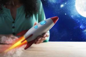 mujer de negocios lanza su empresa con un cohete. concepto de puesta en marcha y innovación foto