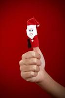 Christmas finger puppet on red background photo