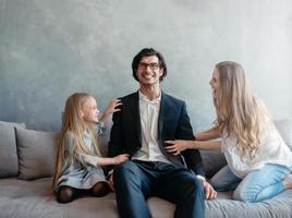 contento pequeño niña jugar con su madre y padre foto