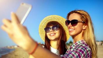 contento grupo de amigo hace un selfie con un móvil teléfono. foto