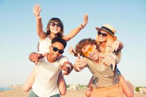 Happy smiling couples playing at the beach photo