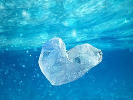 Floating bag. Problem of plastic pollution under the sea concept. photo