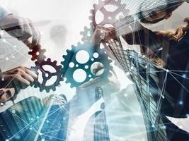 Business team connect pieces of gears. Teamwork, partnership and integration concept. double exposure with network effects photo