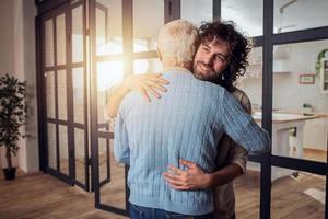 papá y hijo abrazo cada otro a hogar. concepto de familia relación foto