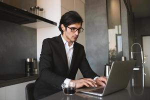 Businessman works from remote at house with a laptop due to coronavirus quarantine. photo