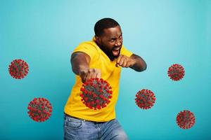 Man attacks with a punch the covid 19 coronavirus. Blue background photo