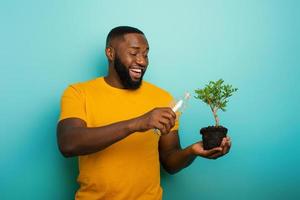 contento chico riego un pequeño árbol Listo a ser plantado. concepto de forestación foto