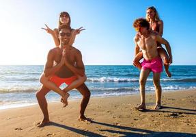 Happy smiling couples playing at the beach photo