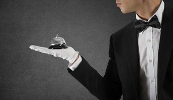 Waiter with bell in hand. Concept of first class service in your business photo