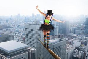 Girl clown walks on a rope over the city photo