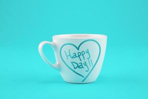 White cup of coffee on a cyan background with wishes for a happy day. photo