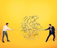 Businessmen try to solve a tangled rope. Concept of partnership photo