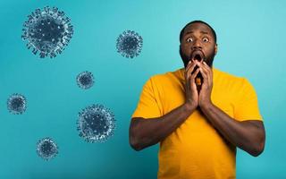 Fearful expression of a boy who is scared to catch the coronavirus. Cyan background. photo