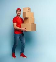 Courier has a lot of boxes to delivery. Emotional expression. Cyan background photo