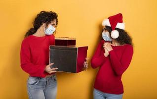 Happy woman receives Christmas gifts from a friend. Yellow background photo