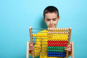 niño intentos a resolver matemático problema con ábaco. cian antecedentes foto