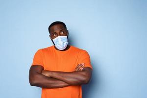 Man with face mask has a lot of questions and doubts about covid 19. cyan background photo