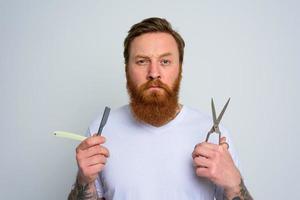 preocupado hombre con tijeras y espada es Listo a cortar el barba foto