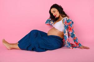Pregnant woman expecting a child caresses her belly photo