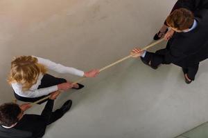 Group of business competitors pull a rope as a challenge photo