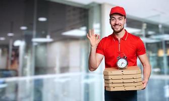 Courier is punctual to deliver quickly pizzas at home photo