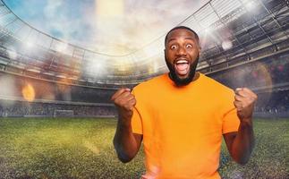 Soccer fan exults watching a football match at the stadium photo