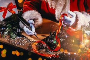 Santa claus writes a letter good wishes for Christmas gifts photo