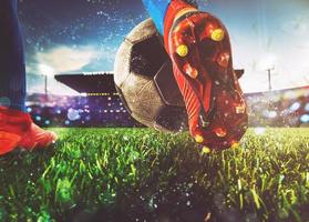 Football scene at night match with close up of a soccer shoe hitting the ball with power photo