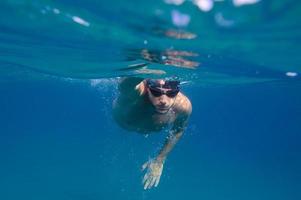 Sporty man swims fast in the sea photo