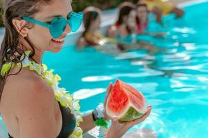 Woman eat a watermelon at the swimming pool photo