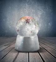 Snow globe on wooden background photo