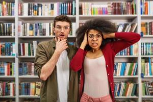 Young student with worried expression in a library photo