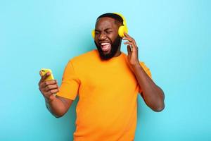 chico con amarillo auriculares escucha a música y bailes emocional y energético expresión foto