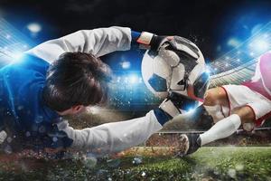 Goalkeeper catches the ball in the stadium during a football game photo