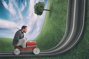 Businessman climb an uphill road with a small car. Difficult carrer concept photo