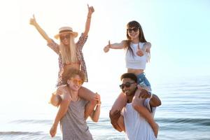 Happy smiling couples playing at the beach photo