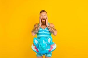 Amazed man with inflatable donut with elephant is ready to swim photo