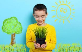 Happy child holds a small tree ready to be planted. Concept of forestation photo