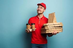 Courier is happy to deliver hot coffee,pizza and food. Cyan background photo