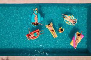 amigos en traje de baño en el piscina consiguiendo un bronceado foto