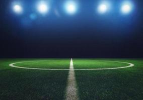 Midfield of grass soccer field at night with headlights photo