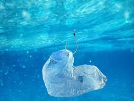 Floating bag. Problem of plastic pollution under the sea concept. photo