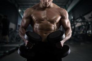 Athletic man training biceps at the gym photo