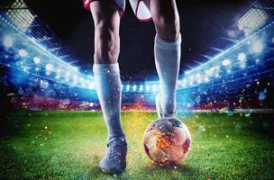 Soccer player with soccerball on fire at the stadium during the match photo