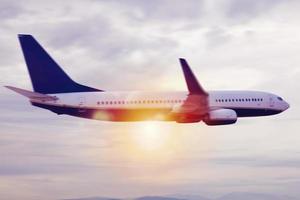 Aircraft flight over the clouds during sunrise photo