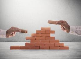 Businessman puts a brick to build a wall. Concept of new business, partnership, integration and startup photo